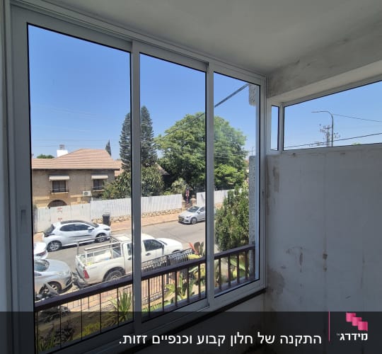 חלון אלומיניום עם נוף לרחוב ועצים